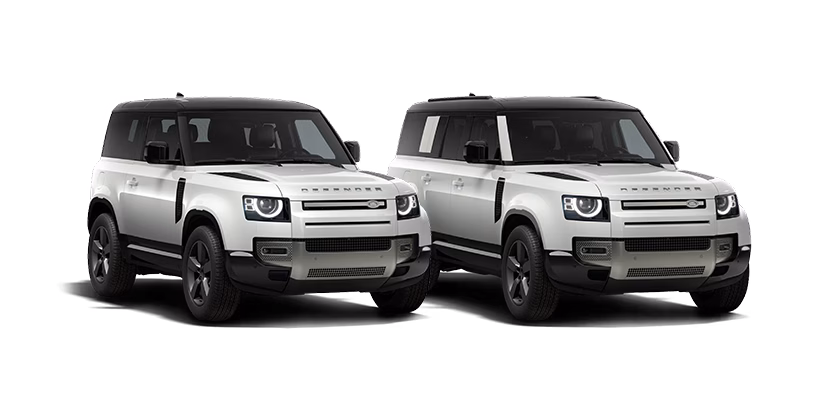 Two white Land Rover Defender family models parked side by side against a white background, showcasing their rugged design.