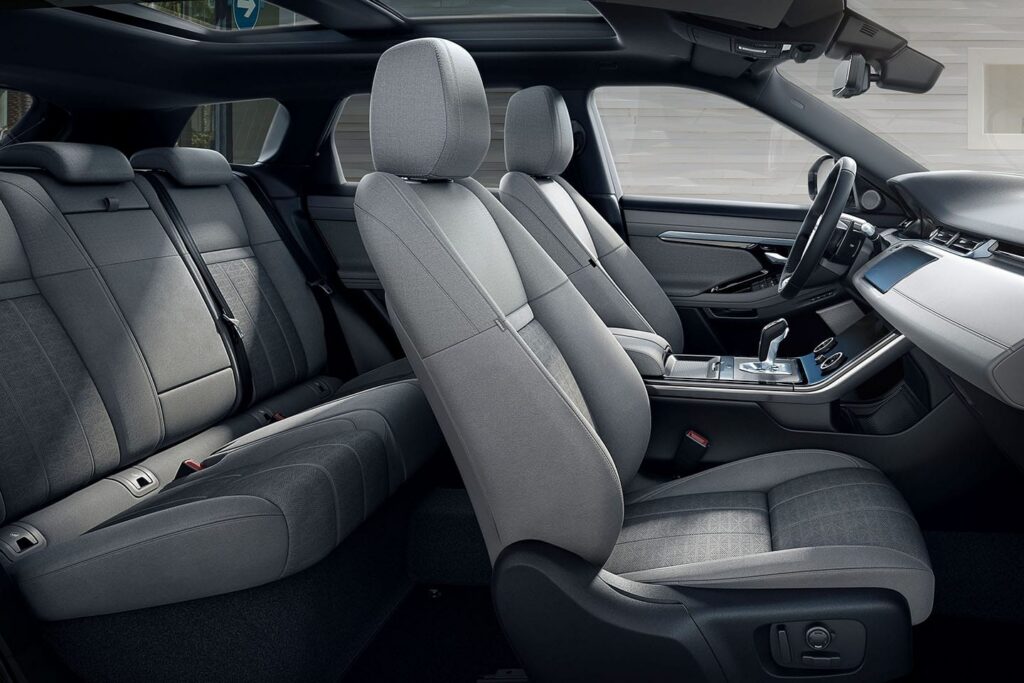 Stylish modern car interior featuring grey fabric seats and a panoramic sunroof, highlighting comfort and design quality.
