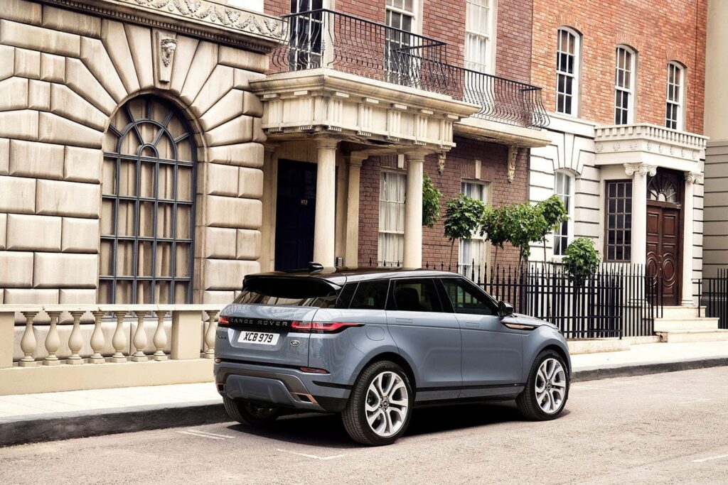 A grey Range Rover Evoque is parked on a city street next to a classic brick and stone building, illustrating stylish urban mobility for the Agreement page.
