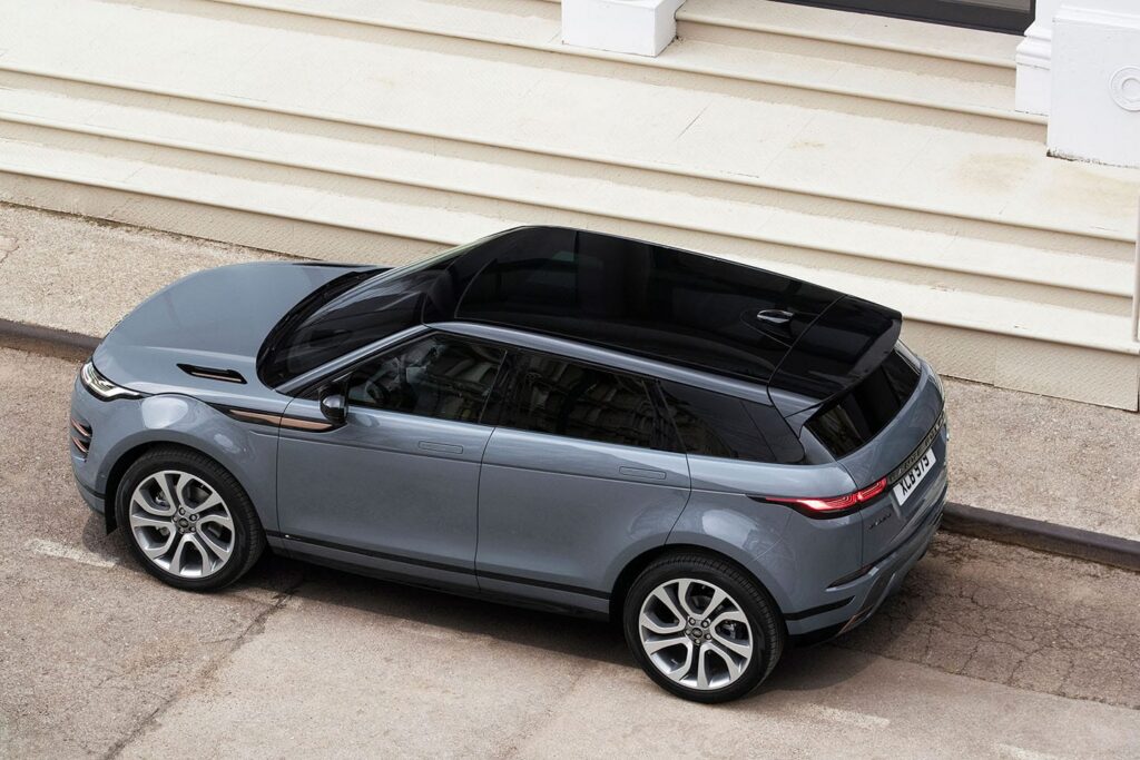 A grey Range Rover Evoque with a contrasting black roof parked beside a cream-coloured building wall