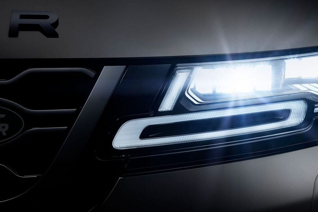 Close-up view of the illuminated Land Rover Defender R front headlight and grille detail
