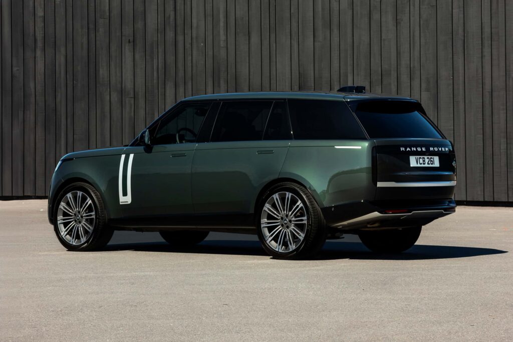Dark green Range Rover parked outdoors against a wooden-paneled wall, representing luxury car rental in London.