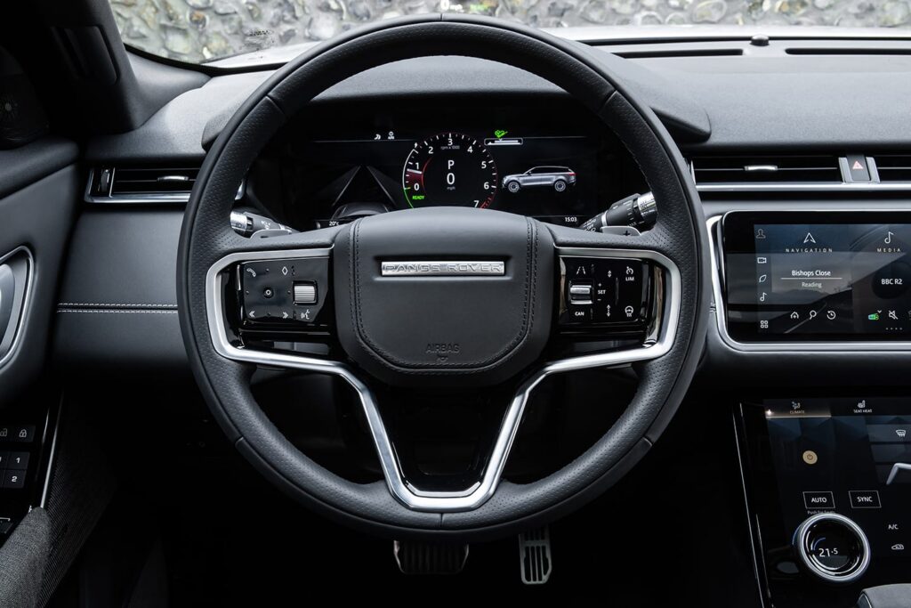 Luxury Range Rover steering wheel featuring a digital instrument cluster and central touchscreen infotainment system