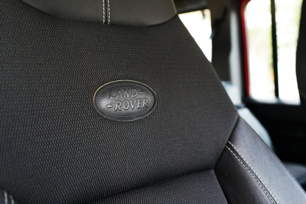 Close-up of Land Rover logo embroidered on a black car seat inside a vehicle
