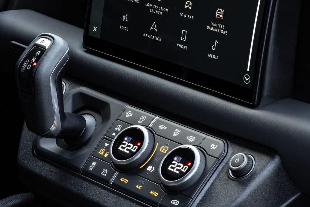 Close-up of a car's interior showing dual zone digital climate control set to 22 degrees and the automatic gear shift in park position