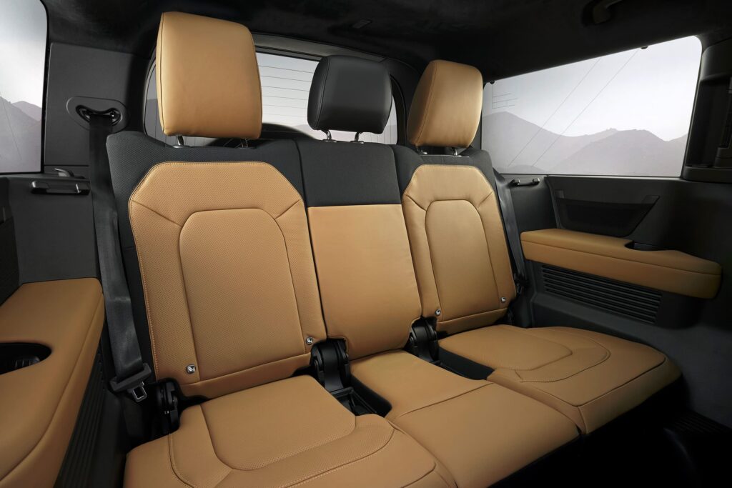 Tan leather upholstered rear seats with headrests and black accents inside a car