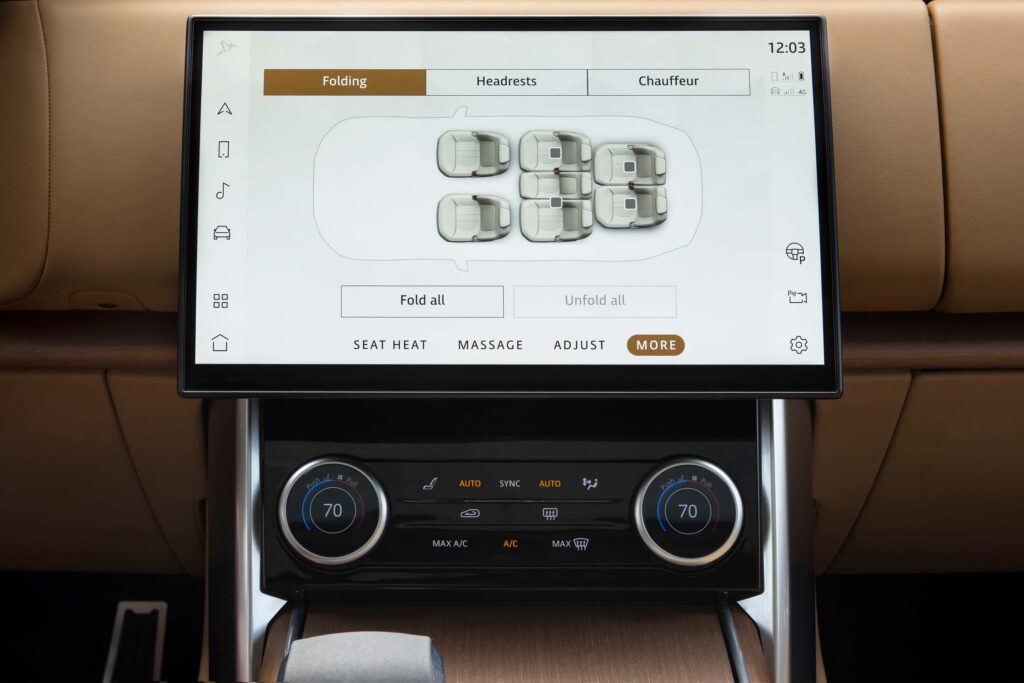 Car dashboard touchscreen showing seat folding controls with options for folding all seats and navigation for headrests and chauffeur settings.