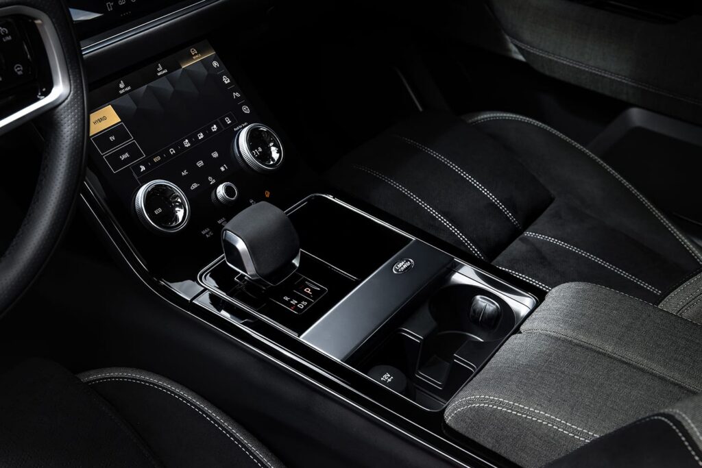 Close-up view of the Land Rover hybrid car interior showing the central control panel with gear selector and touchscreen display