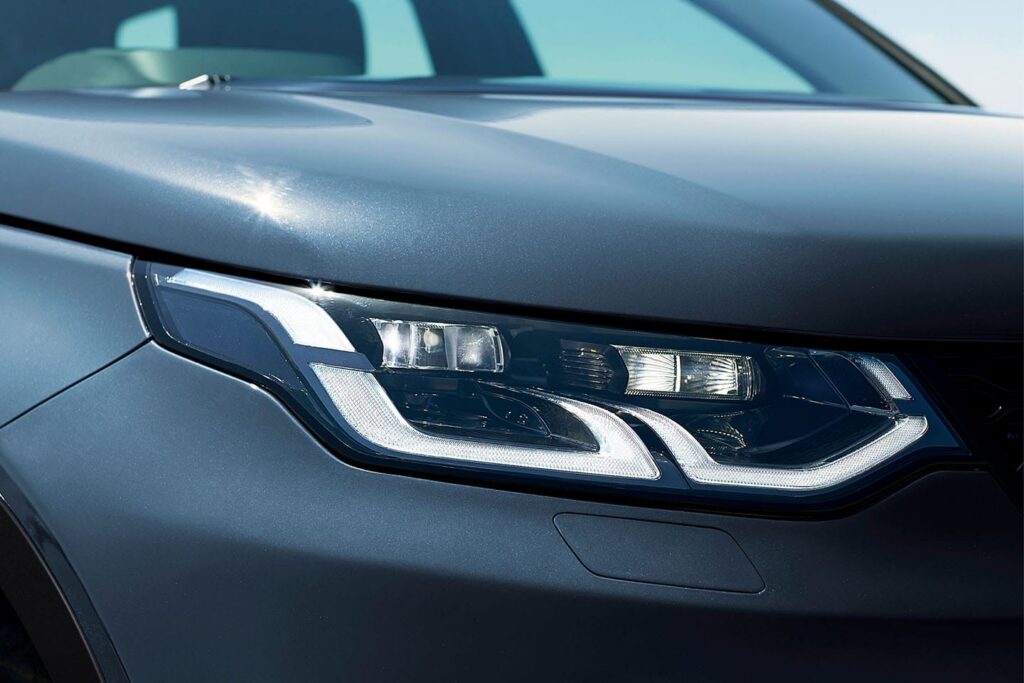 Close-up of a modern car's headlight with distinctive LED design reflecting natural light
