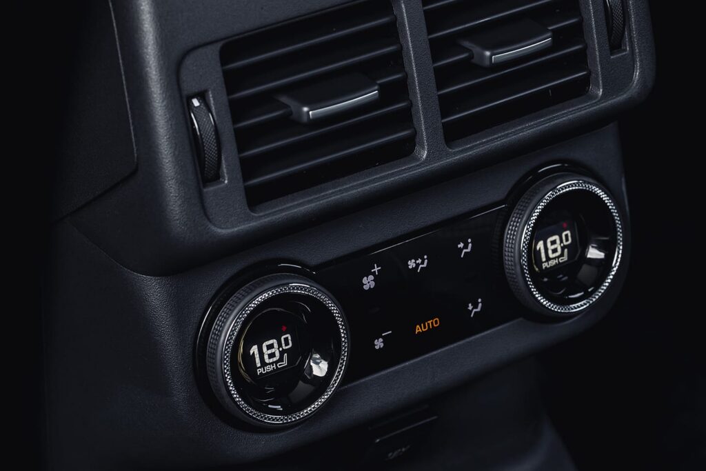 Close-up of a car's dual-zone climate control system showing 18 degrees temperature settings and air flow direction icons