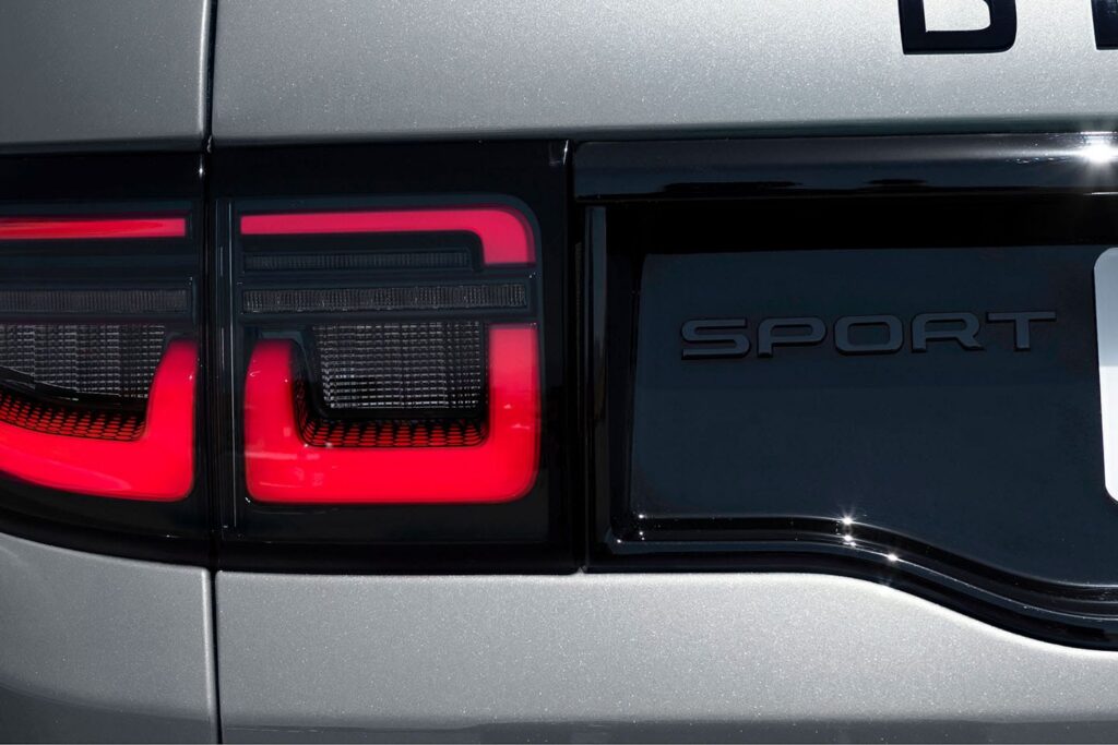 Close-up of the rear light and SPORT badge on a silver Land Rover Sport vehicle