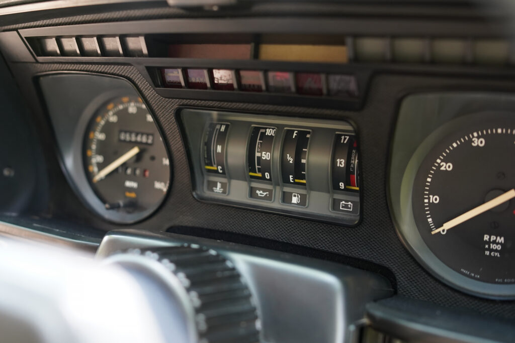 Close-up of a classic car dashboard showing various gauges including speedometer, fuel, temperature, oil pressure, and RPM