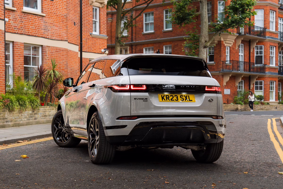Silver Range Rover Evoque parked on a city street with red brick buildings in the background